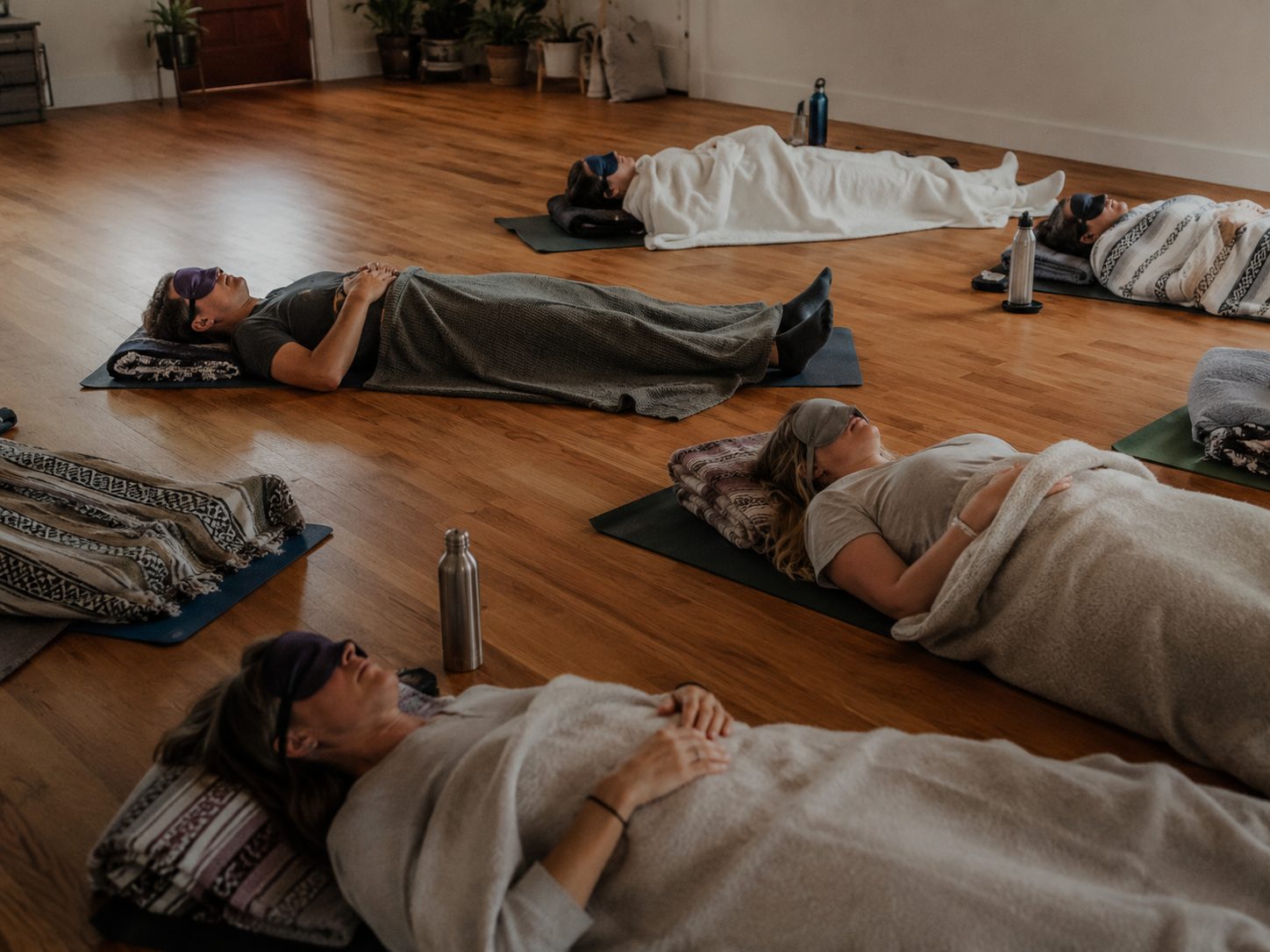 Gehaltene Session – Teilnehmende ruhen unter Decken in einem Selbsterfahrungsretreat
