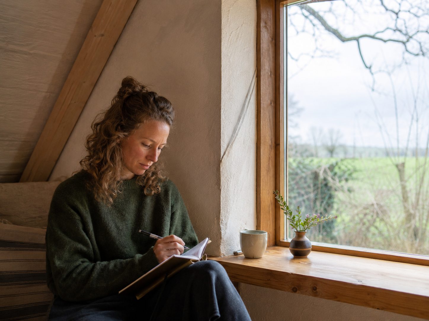 Frau schreibt journaling am Fenster